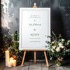 Printable wedding welcome sign on an easel with floral arrangements in a room setting.