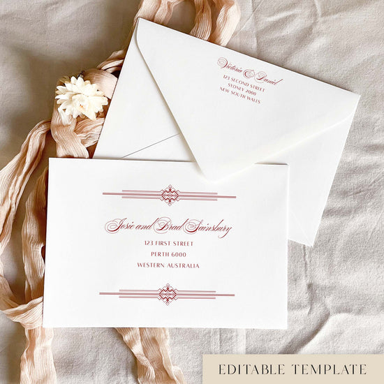 Art Deco editable wedding envelope address template in Canva, with red text on a white envelope. The calligraphy guest names sit between double-rule geometric borders, and the back flap shows a matching return address, styled with blush pink ribbon and a cream dried flower.