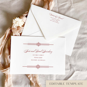 Art Deco editable wedding envelope address template in Canva, with red text on a white envelope. The calligraphy guest names sit between double-rule geometric borders, and the back flap shows a matching return address, styled with blush pink ribbon and a cream dried flower.