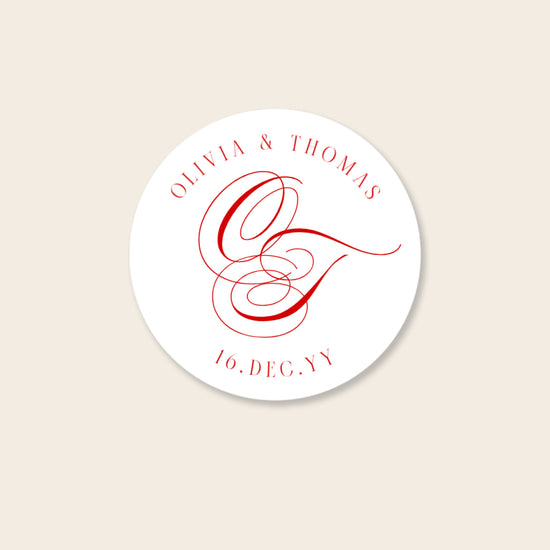 Round white invitation seal with red monogram text on a beige background.