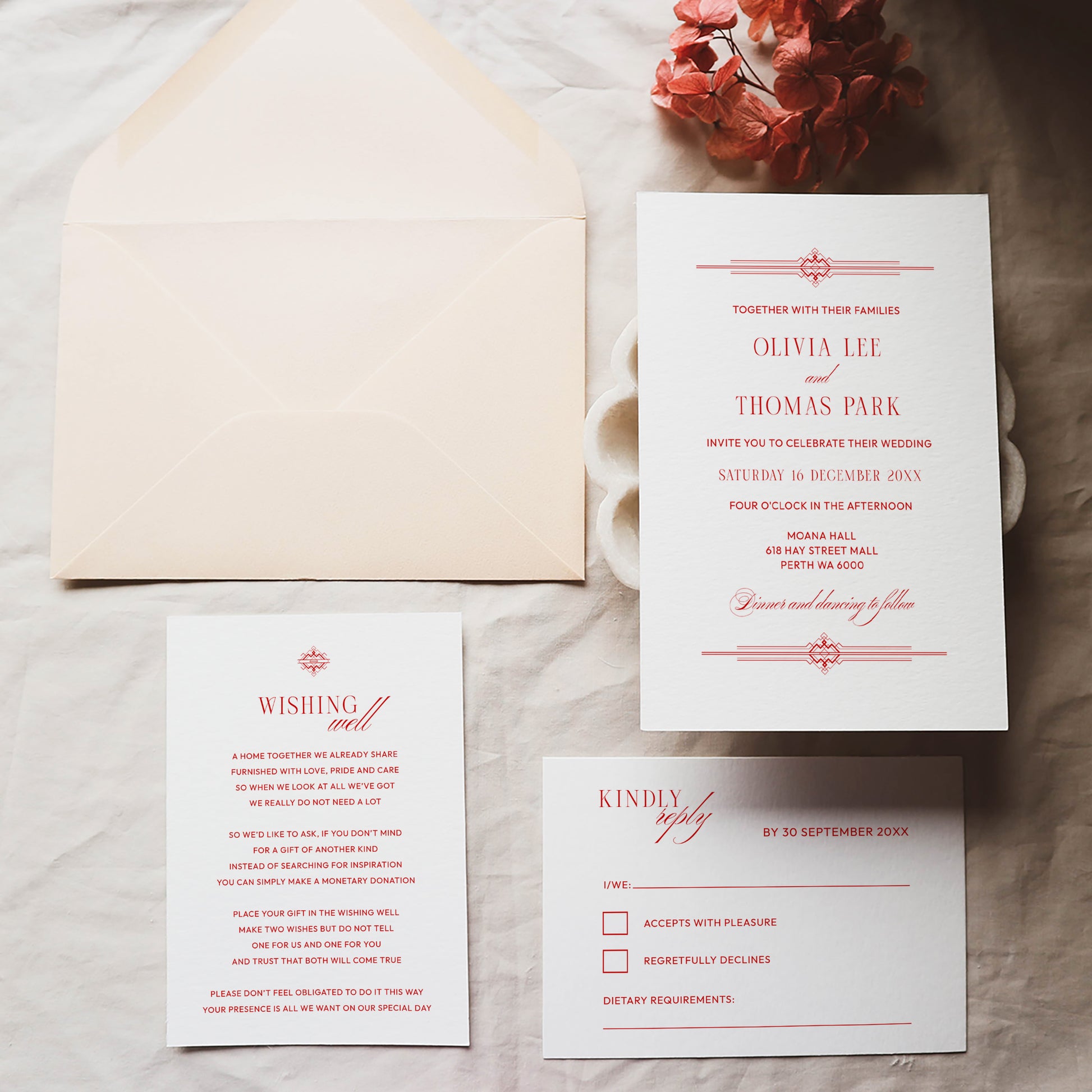 Wedding invitation, details card, RSVP card and envelope on a textured surface.