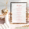 Printable wedding menu template in a gold frame on a soft pink tablecloth with dried florals and modern decorative accents.