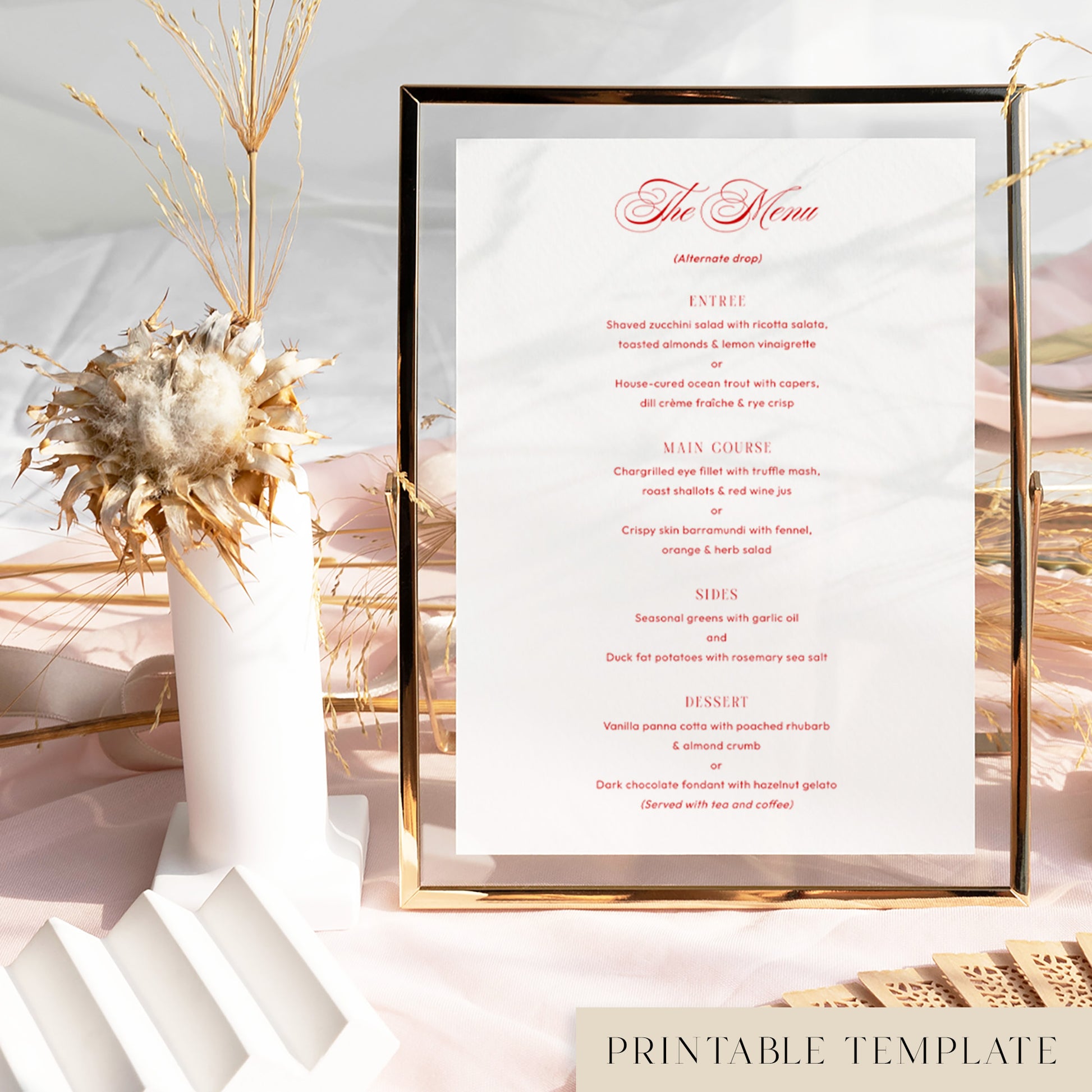 Printable wedding menu template in a gold frame on a soft pink tablecloth with dried florals and modern decorative accents.