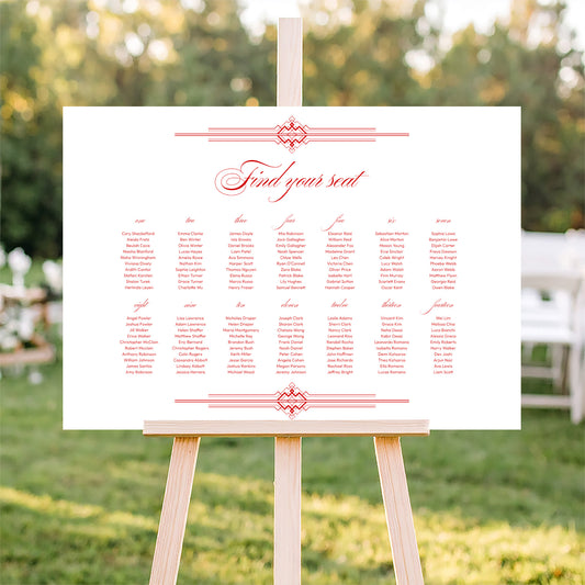Horizontal wedding seating plan sign on an easel with a blurred outdoor ceremony background.
