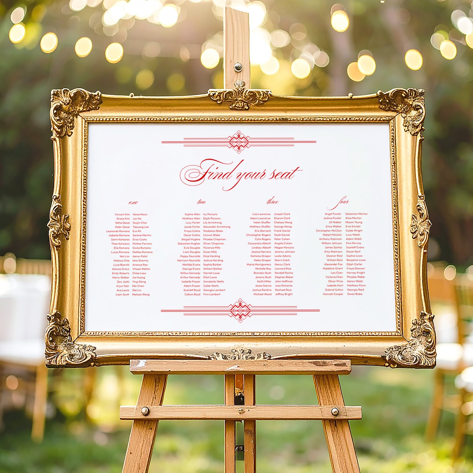 Decorative gold frame on an easel with a horizontal wedding seating chart outdoors.