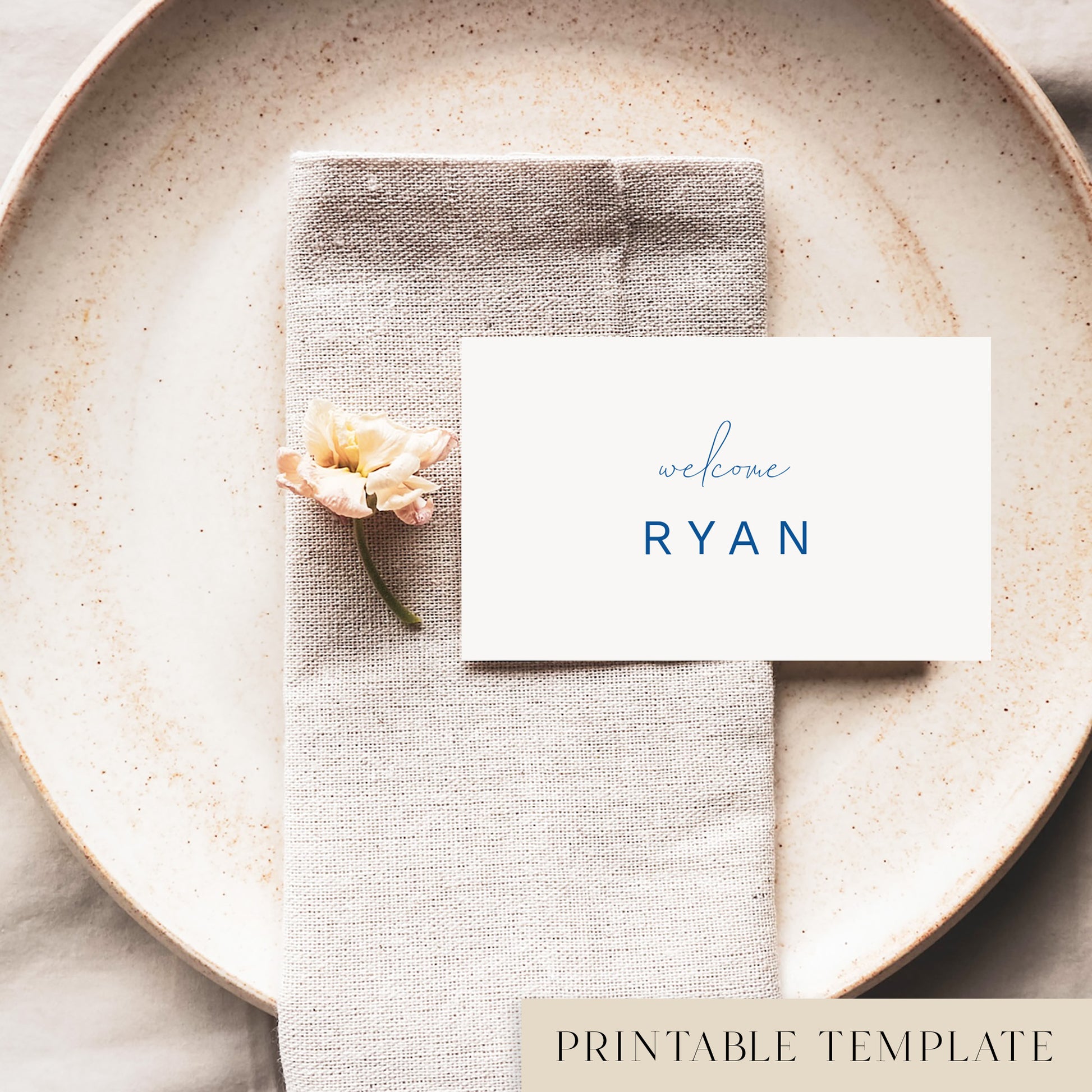 A flat place card with a name printed on it, positioned on a plate with a napkin and a floral decoration.