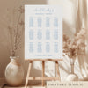 Printable minimal wedding seating chart sign on an easel with floral arrangements in a room setting.