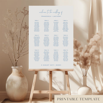 Printable minimal wedding seating chart sign on an easel with floral arrangements in a room setting.