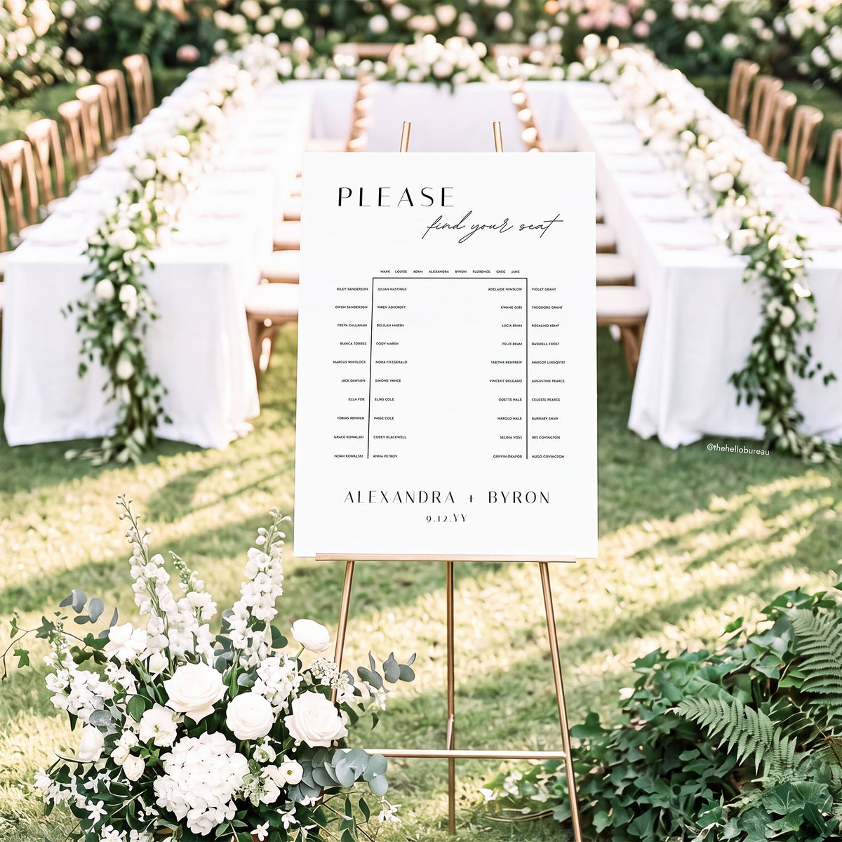 Printable horseshoe seating chart on an easel in front of a u-shaped wedding table setting with white florals
