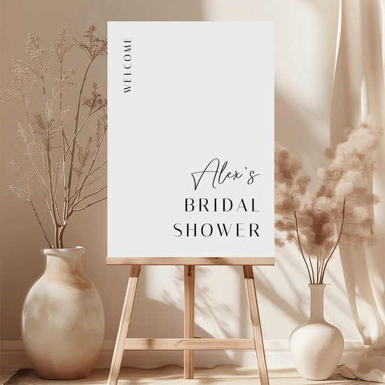White printable bridal shower welcome sign template with floral decorations and a wooden easel.