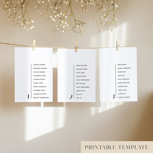Three white seating chart cards with printed names, clipped to a string with pegs, against a neutral background.