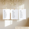 Three white seating chart cards with printed names, clipped to a string with pegs, against a neutral background.