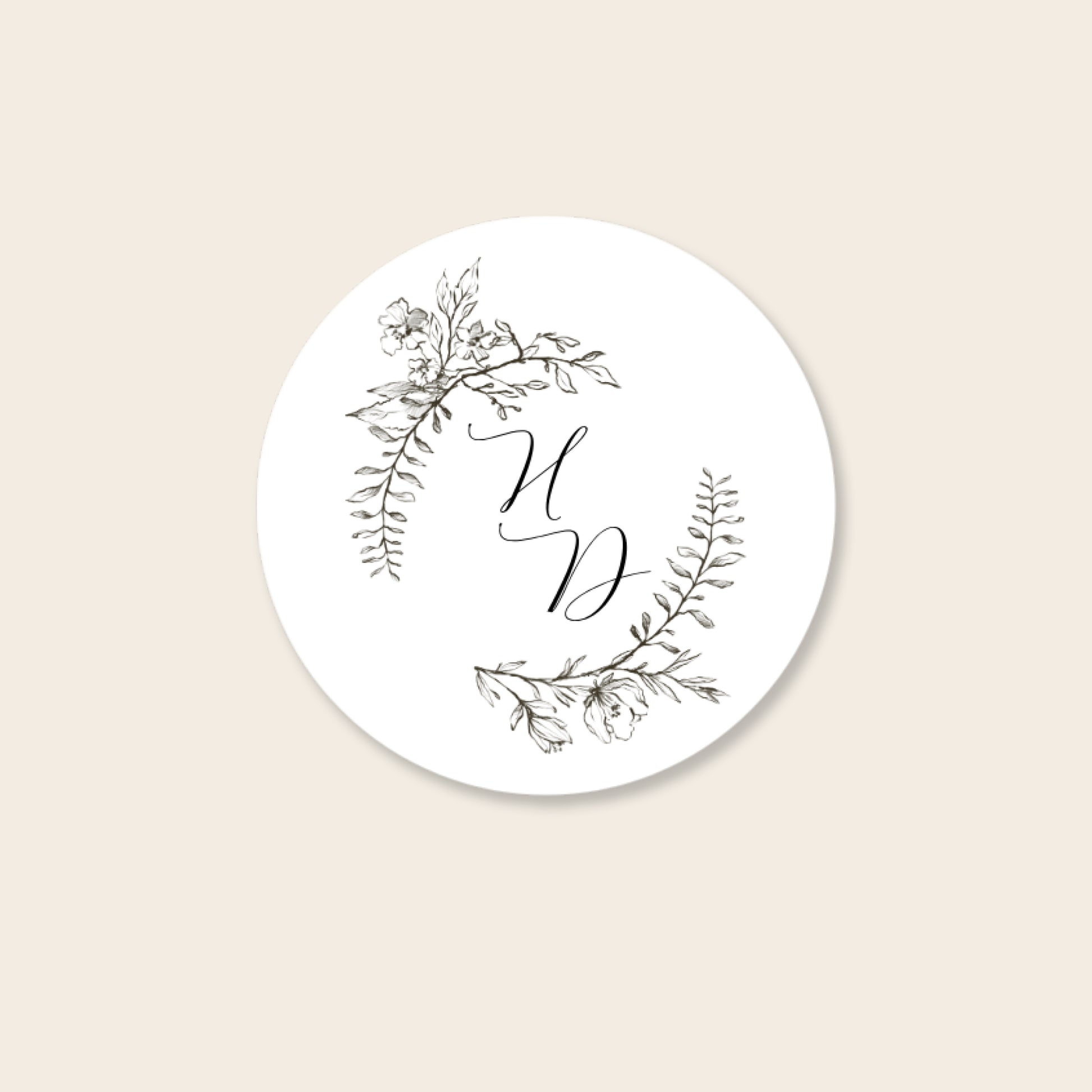 Round white invitation seal with monogram text on a beige background.
