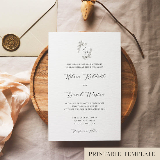 Elegant wedding invitation template design on a white card sitting on a wooden plate with decorative elements.