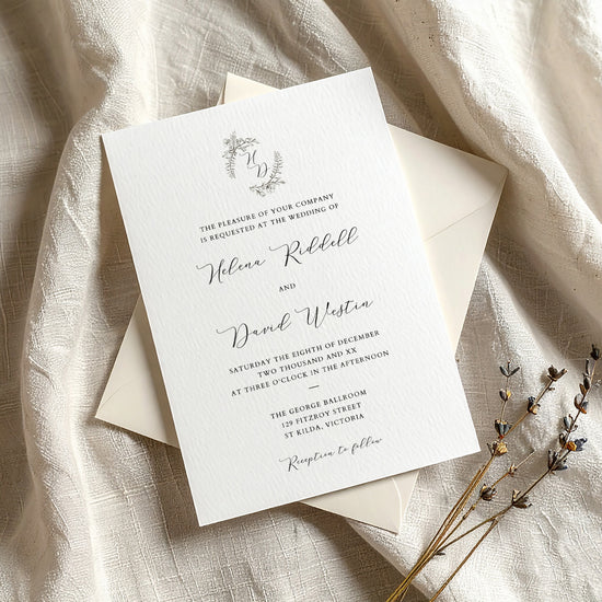 Wedding invitation template on textured card with envelope on fabric background.