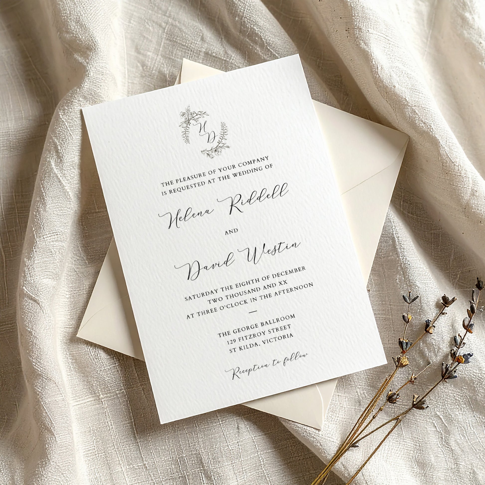 Wedding invitation template on textured card with envelope on fabric background.