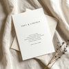 Wedding invitation template on textured card with envelope on fabric background.