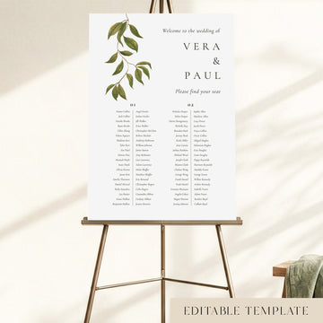 A 2-long-table wedding seating chart displayed on an easel, with hand-painted greenery and guest names