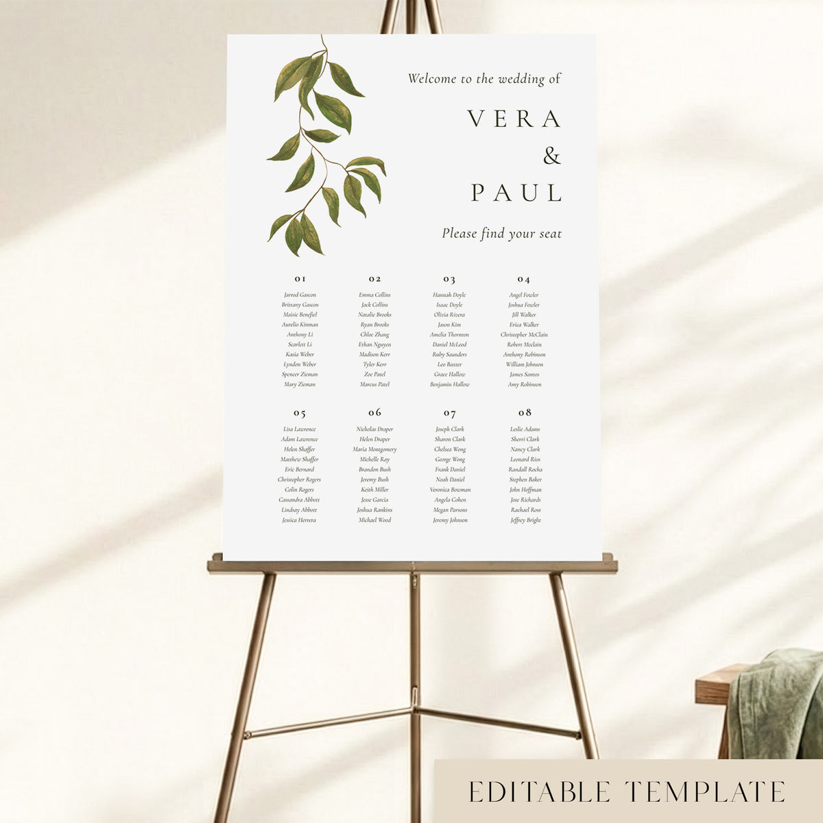 A wedding seating chart for 8 tables displayed on an easel, with hand-painted greenery and guest names