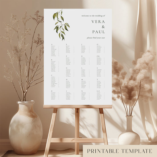Printable alphabetical wedding seating chart sign on an easel with floral arrangements in a room setting.