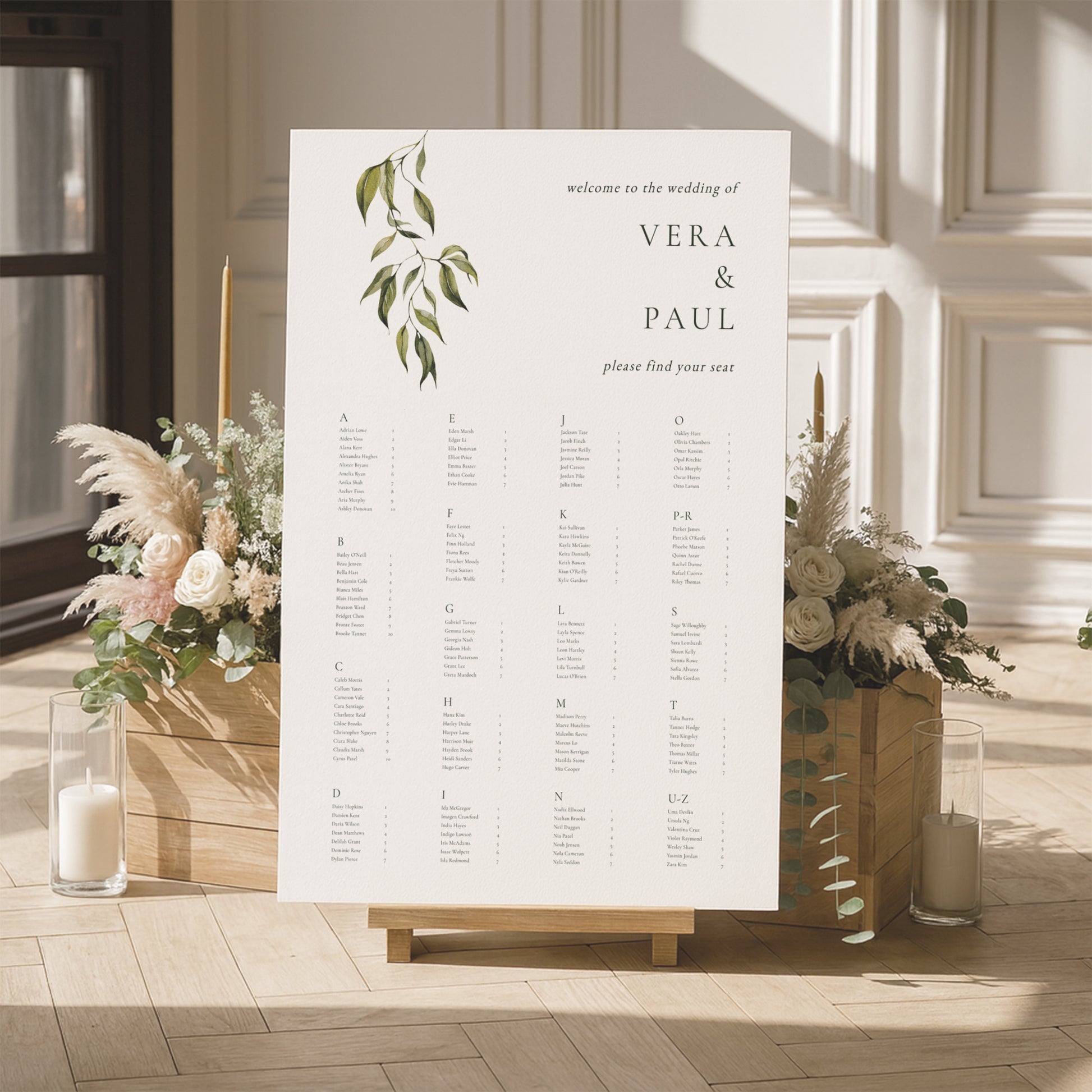 Modern alphabetical seating chart for a wedding with floral arrangements and candles in a room.