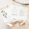 A5 wedding Mass ceremony booklet shown open with the cover beside it, styled on light fabric with dried florals and a soft ribbon.