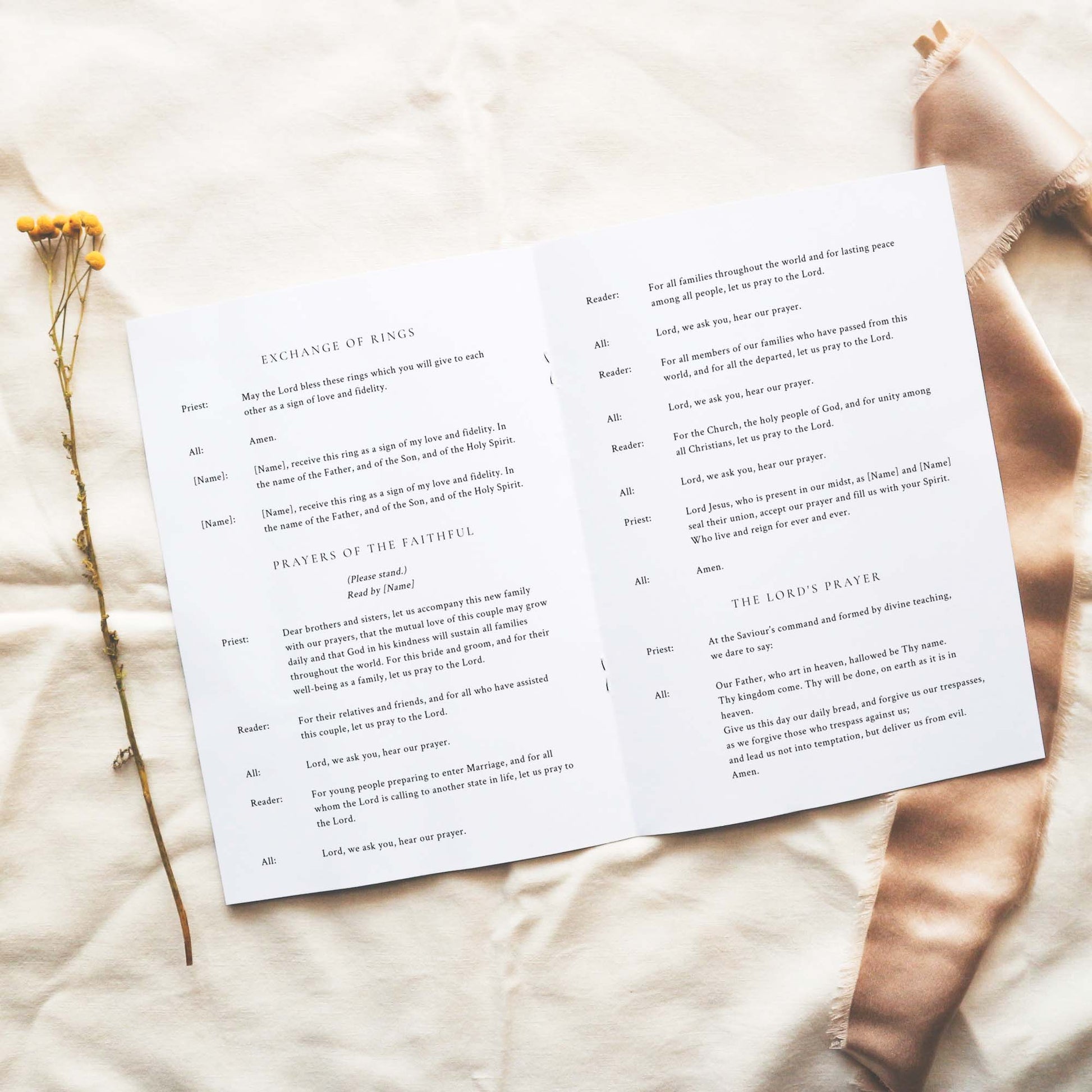 Open A5 wedding Mass ceremony booklet displaying interior ceremony text on a neutral fabric background.