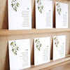Set of six printable seating chart cards with names on a wooden display shelf.