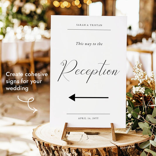 "This way to the Reception" wedding directional sign with a left arrow, displayed on a small wooden easel at a rustic reception.