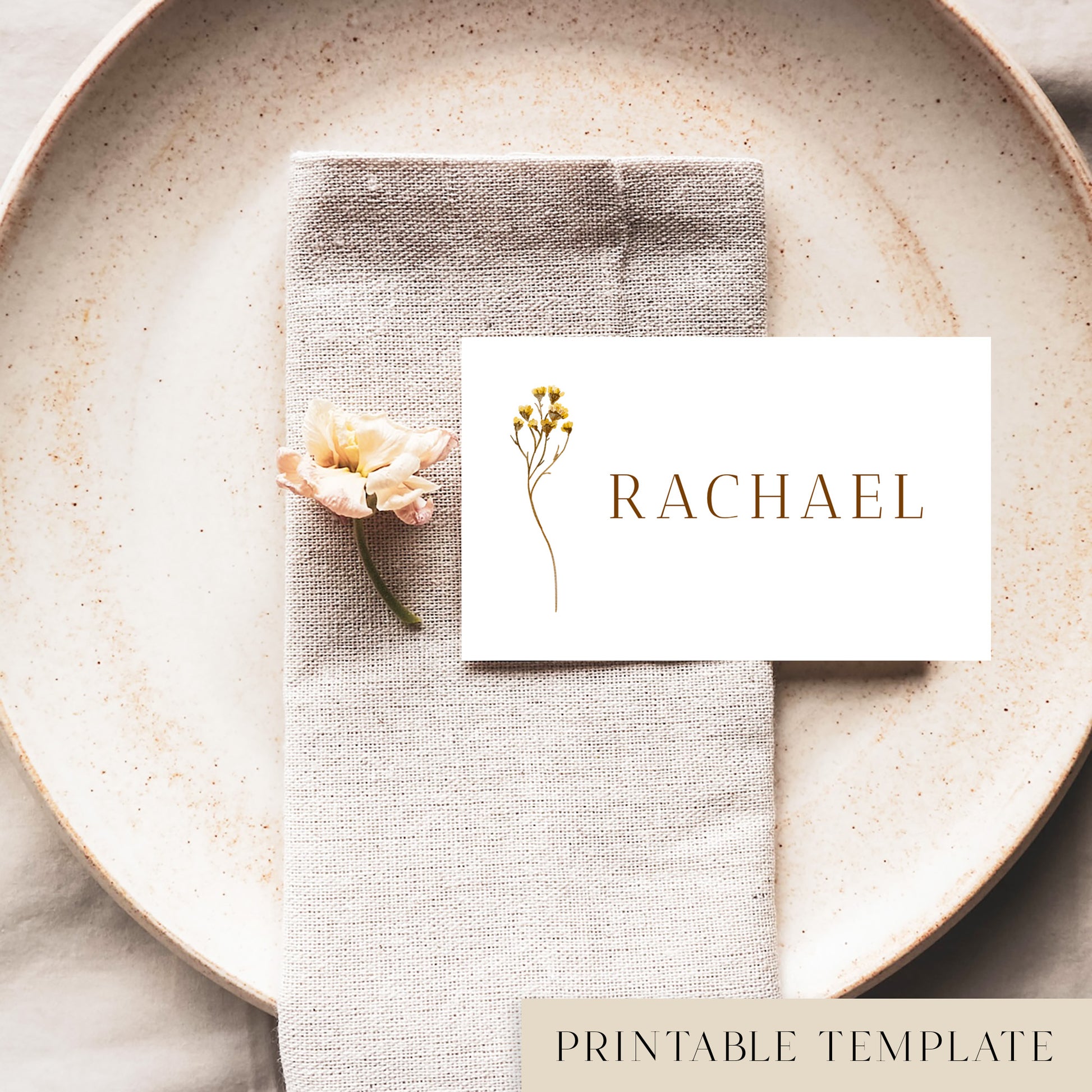 A flat place card with a name printed on it, positioned on a plate with a napkin and a floral decoration.