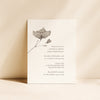 Bridal shower invitation with floral design standing upright on a beige background.