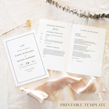 Elegant A5 Catholic wedding Mass ceremony booklet shown open with the cover beside it, styled on light fabric with dried florals and a soft ribbon.