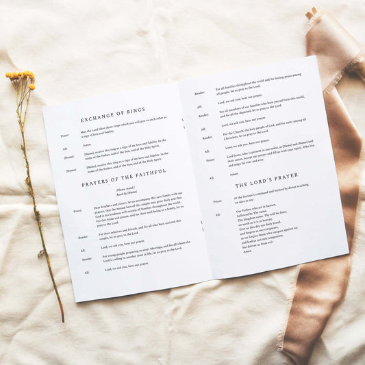 Open A5 church wedding ceremony booklet displaying text on a neutral fabric background.