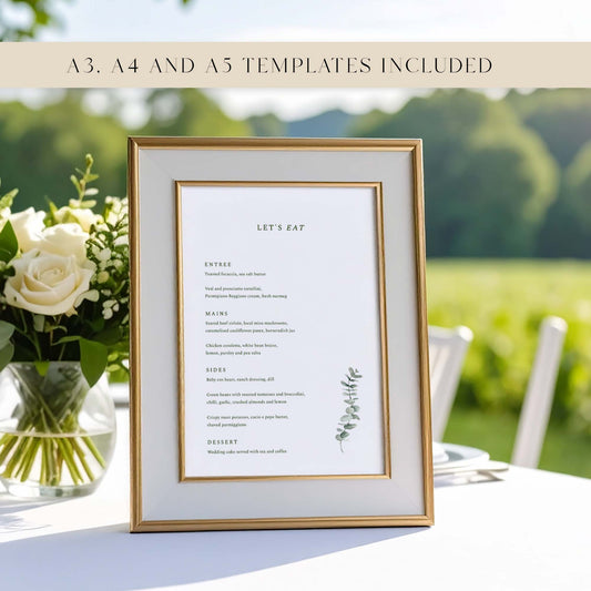Framed wedding menu with floral arrangement on a table at an outdoors wedding.