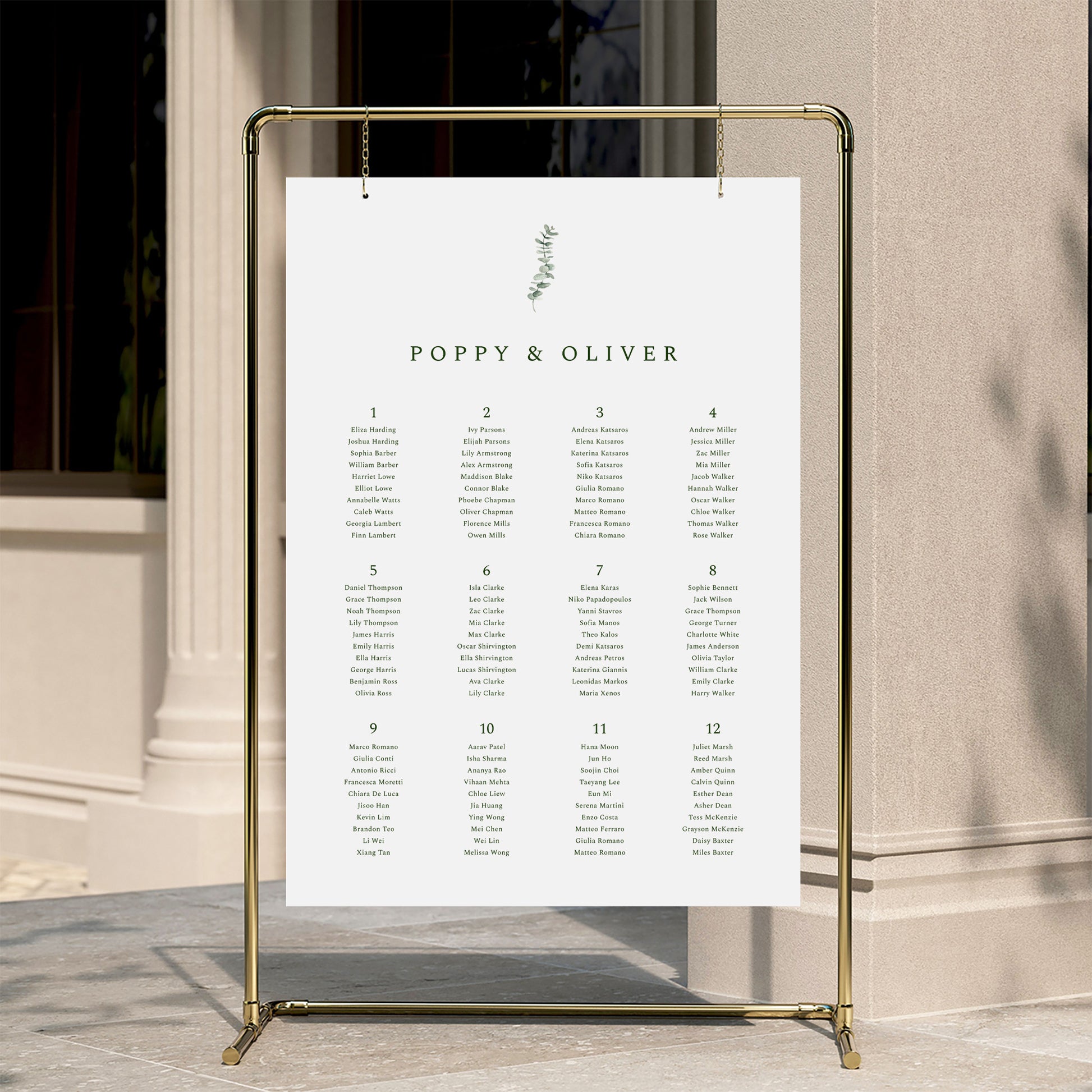 Minimal wedding seating chart template displayed on a gold stand against a neutral wall.