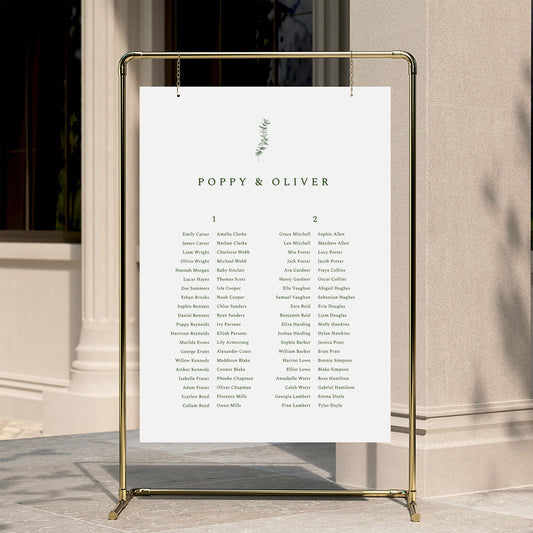 Minimal wedding seating chart template displayed on a gold stand against a neutral wall.