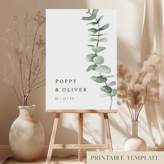 Printable minimal wedding welcome sign with leaf illustration on an easel with floral arrangements in a room setting.