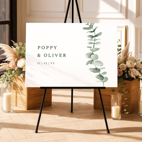 Modern welcome sign template on an easel with floral arrangements and candles in a decorative setting.