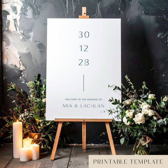 Printable minimal wedding welcome sign on an easel with floral arrangements in a room setting.