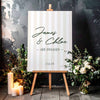 Preppy stripe engagement party sign on a wooden easel, surrounded by flowers and candles.