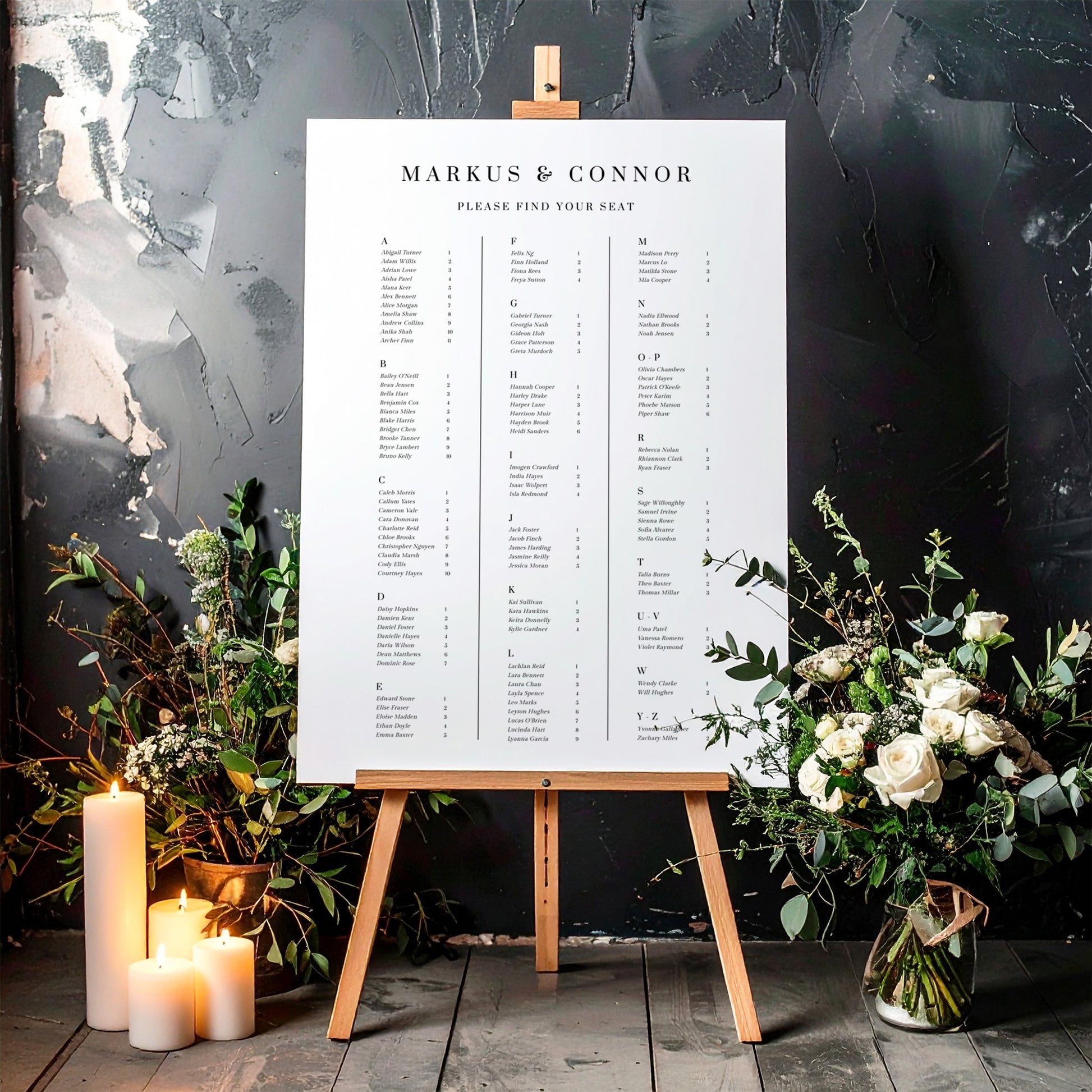 Printable alphabetical wedding seating chart sign on an easel with floral arrangements in a room setting.