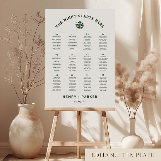 Modern 12-table seating chart template on an easel with decorative vases and plants.