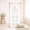 Gold frame with a hanging white linen wedding seating chart.