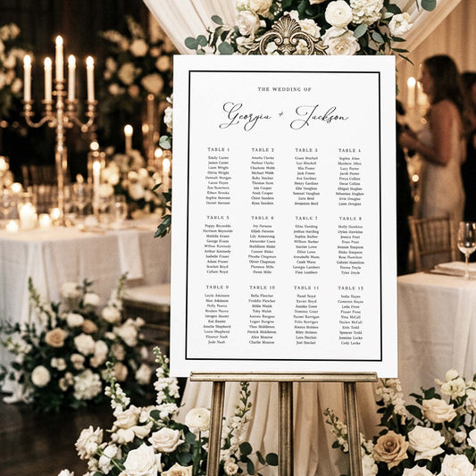 Wedding seating chart template from The Hello Bureau on a gold easel with white floral decorations.