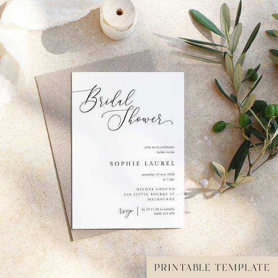 Bridal shower invitation card on a textured surface with olive branches