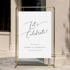 Elegant engagement party welcome sign displayed on a gold stand against a neutral wall.