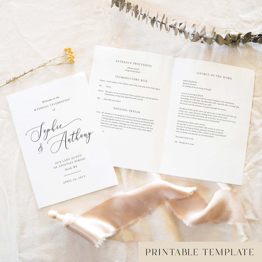 A5 wedding Mass ceremony booklet shown open with the cover beside it, styled on light fabric with dried florals and a soft ribbon.