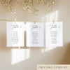Three white seating chart cards with printed names, clipped to a string with pegs, against a neutral background.