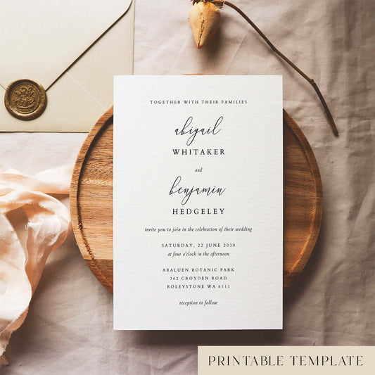 Elegant wedding invitation template design on a white card sitting on a wooden plate with decorative elements.