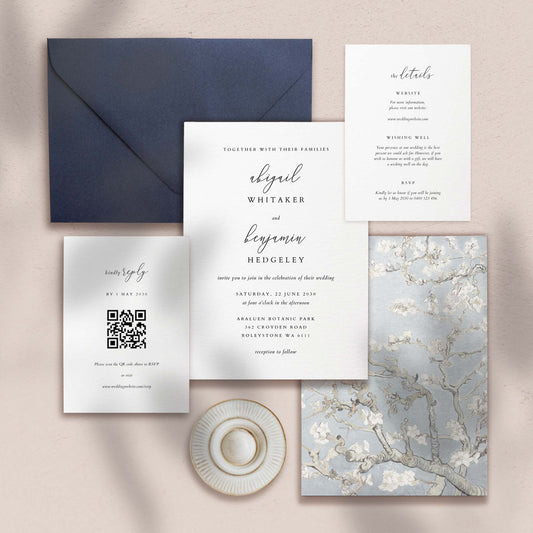 Wedding invitation, details card, RSVP card and envelope on a textured surface.